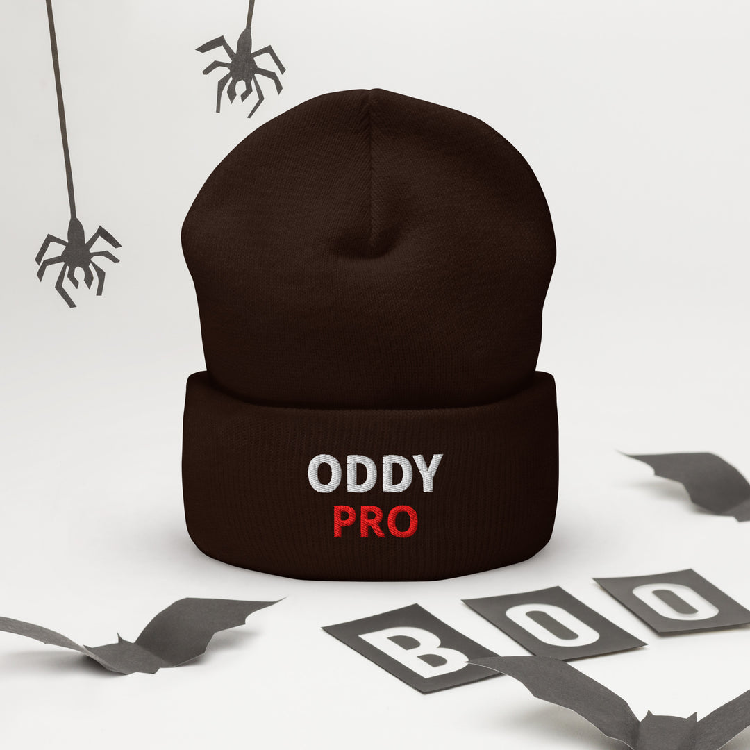 Oddy Pro cuffed beanie displayed with Halloween decorations and spiders.