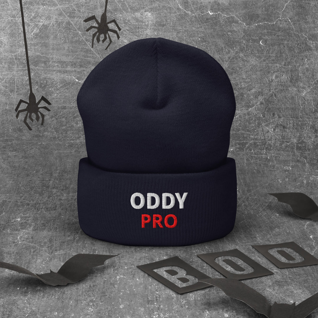 Oddy Pro cuffed beanie displayed on a textured background with Halloween-themed decor.