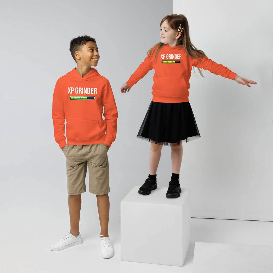 Two kids wearing XP Grinder eco-friendly kids hoodie, a boy in shorts and a girl in a skirt, standing on a cube.